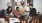 a group of people sitting on a couch playing a guitar