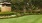 a lawn with a brick building and trees