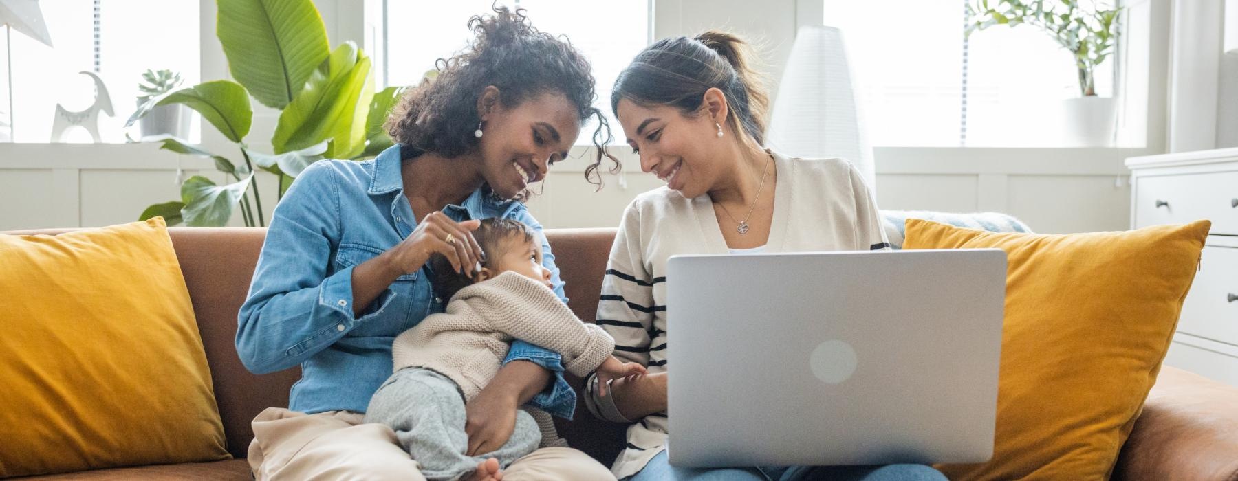 a person and a child on a couch with a laptop